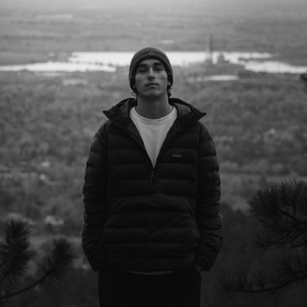 Black and white photo of a person standing at a viewpoint