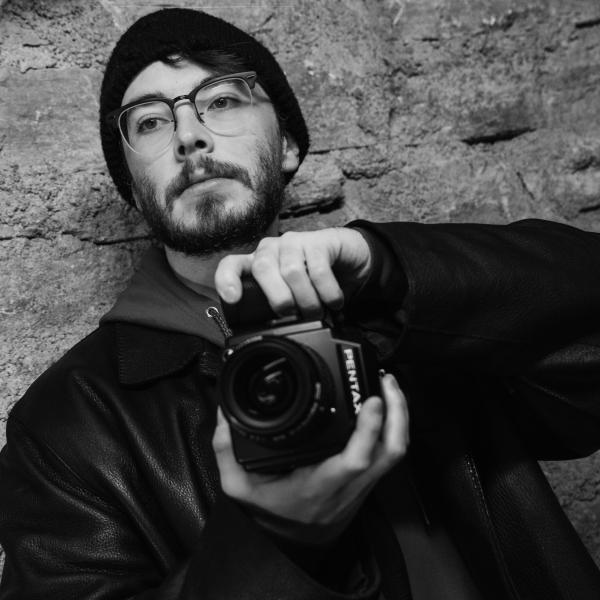 Black and white photo of a person taking a photo with a Pentaz camera