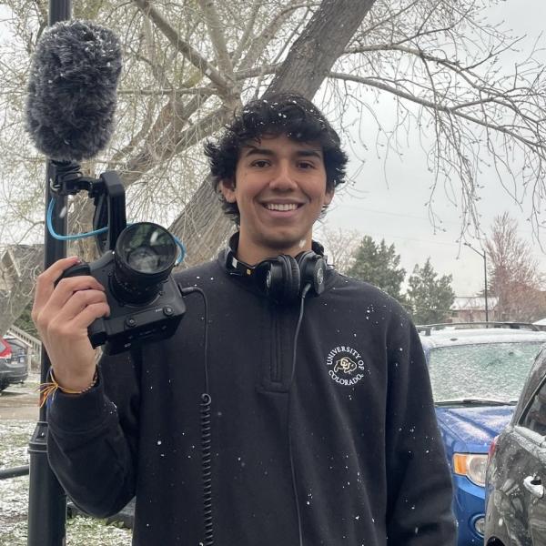 Portait of man holding a camera in the snow
