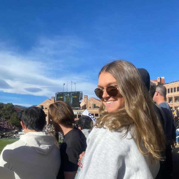 woman with sunglasses standing in a crowd