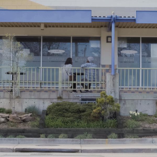 Two people sitting outside a catering company
