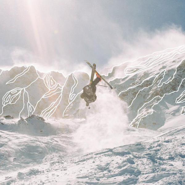 Person skiing in the mountains doing a flip