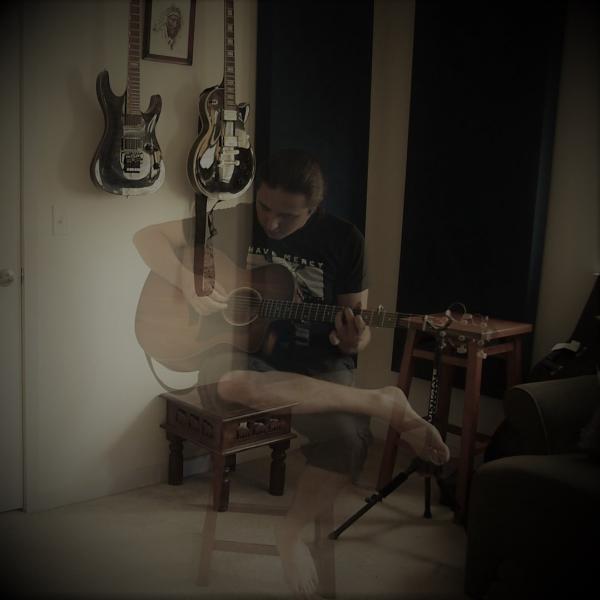 Person sitting on chair playing guitar