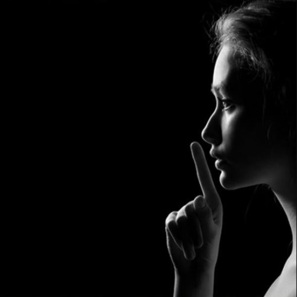 Side profile of a person with finger to lips