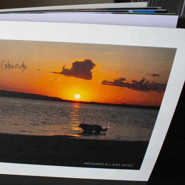 Photo book with a sunset at sea is propped on a table