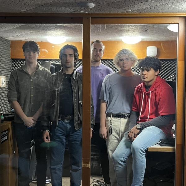 band standing behind a glass wall
