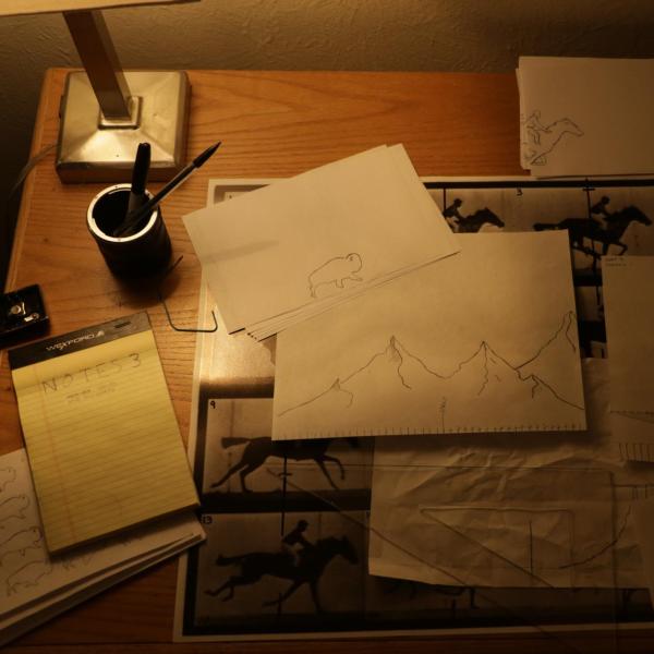 Pieces of paper on a desk with hand drawn animations