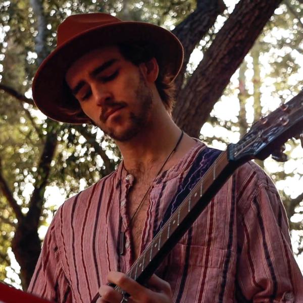 Person with a hat playing guitar