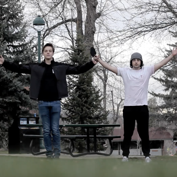 Two men on the grass holding hands in the air