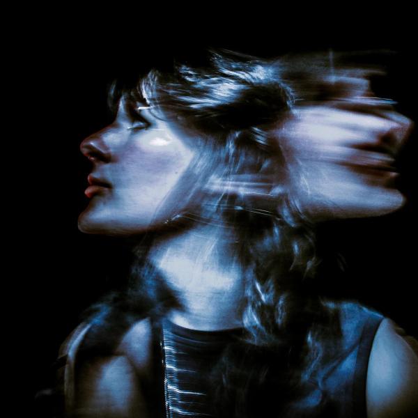 Erp Phillips - An artistic photo capturing a person's face in profile with a motion blur effect creating a double exposure on a dark background