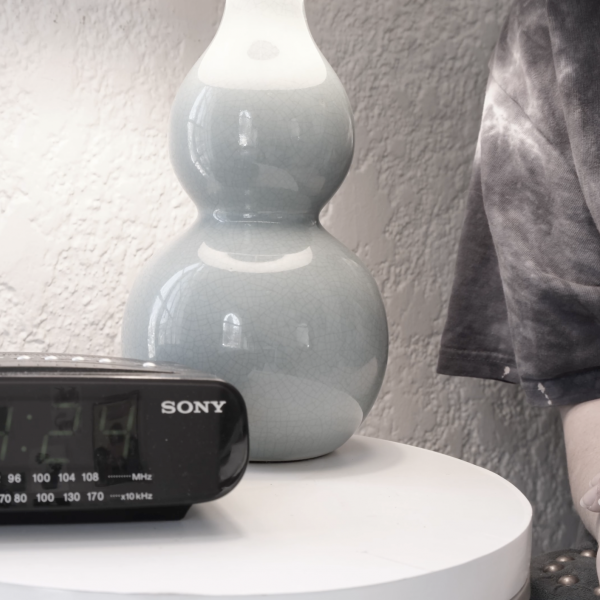 Alarm clock with the time 4:24 sits on bedside table