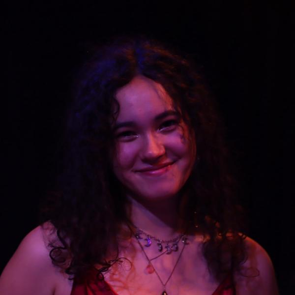 Lauryn Iverson - A person smiling at the camera, indoors with a soft-focus background.