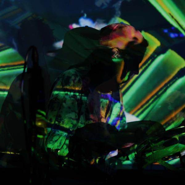 Person playing music with colorful video projections over them