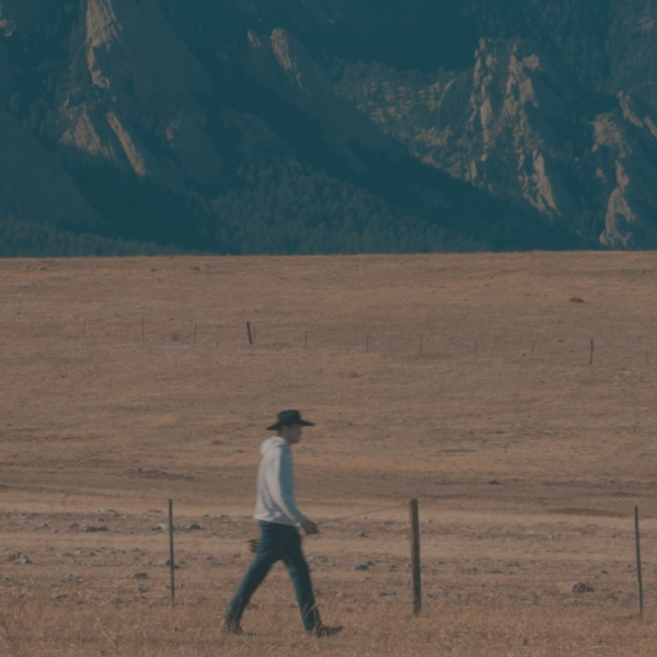 Man walking with fishing rod in the countryside