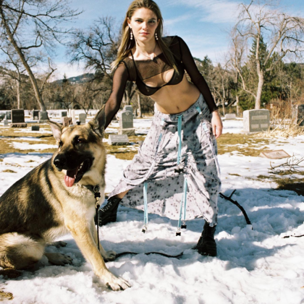 Woman in fashion outdoors with a german Shepard dog by her side