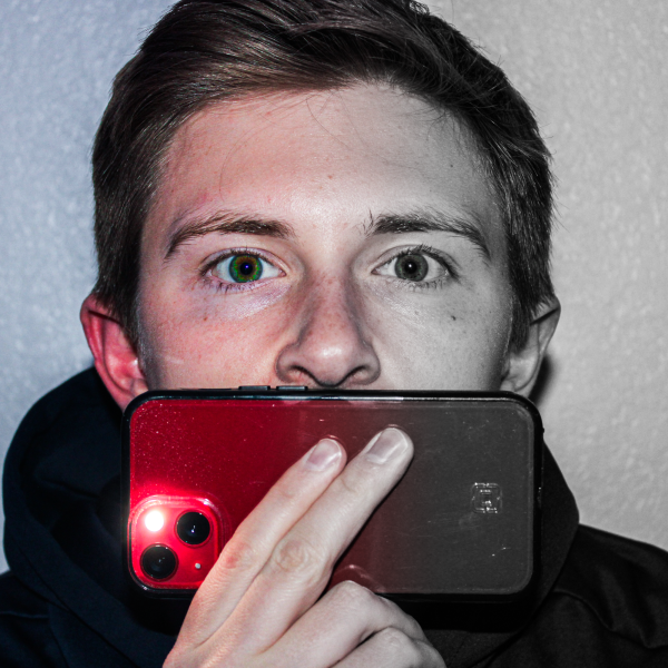 Person holding a red mobile phone to their face