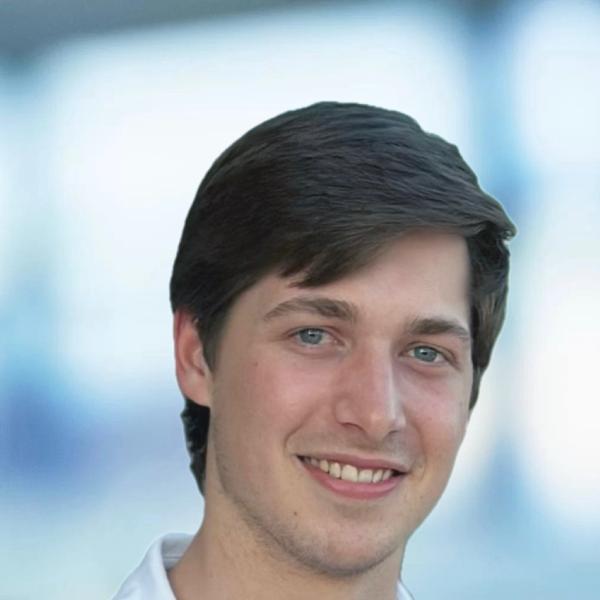 Chancellor Pollock - A portrait of a young man with a smile, wearing a white shirt, with an out-of-focus light background