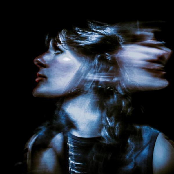Erp Phillips - An artistic photo capturing a person's face in profile with a motion blur effect creating a double exposure on a dark background