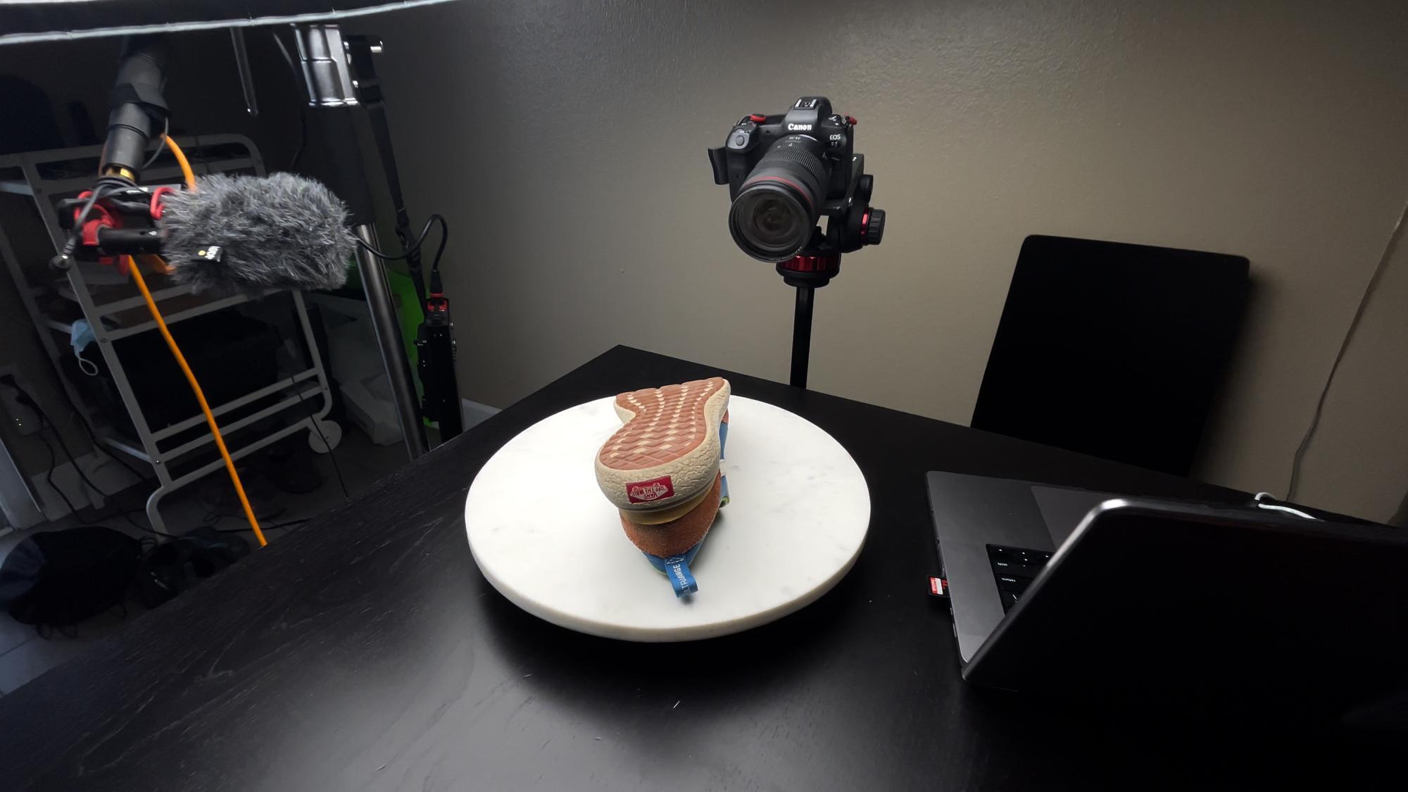 Picture of shoe on white turntable with softbox directly above.
