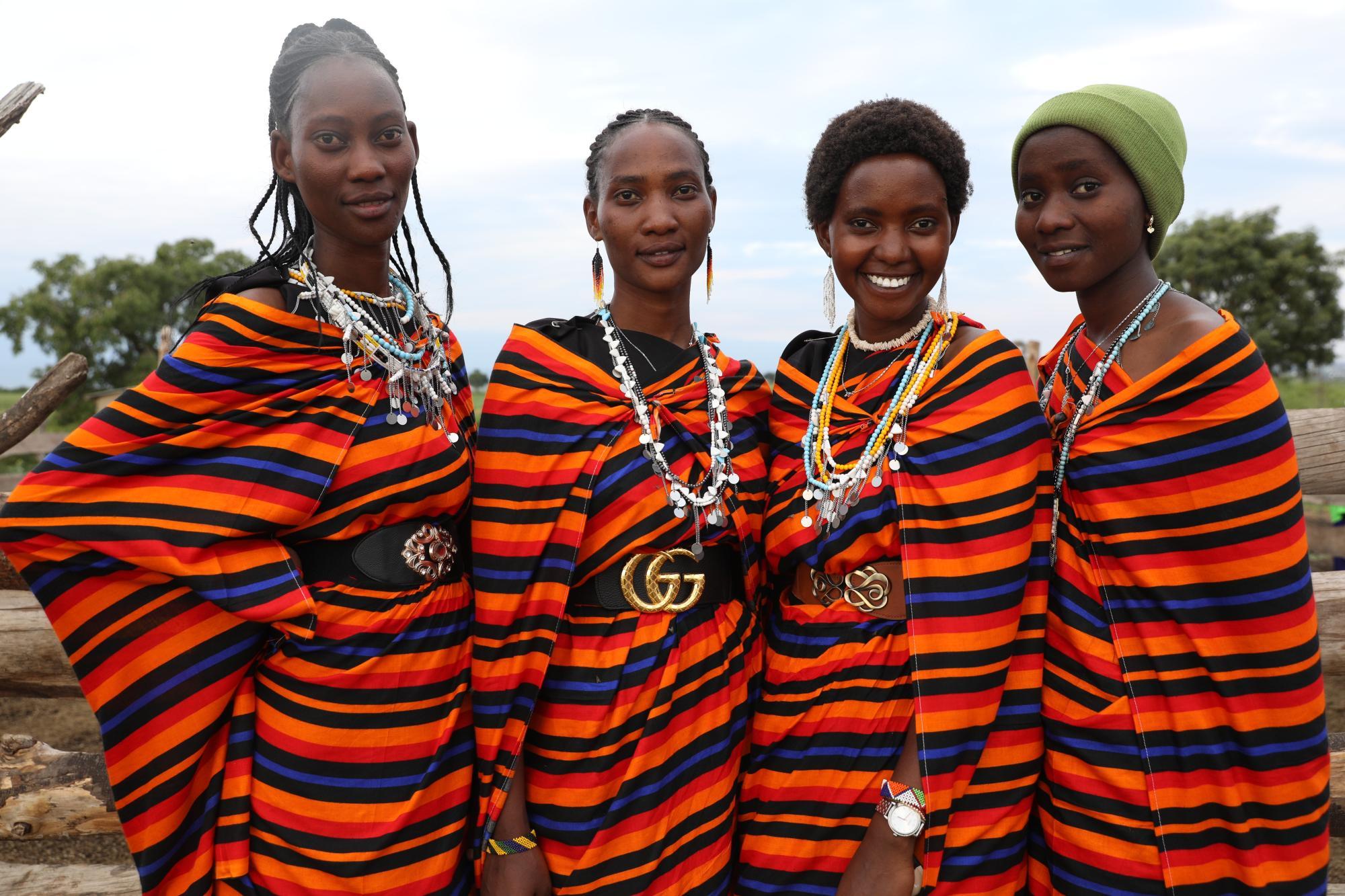 four women standing together with striped clothing