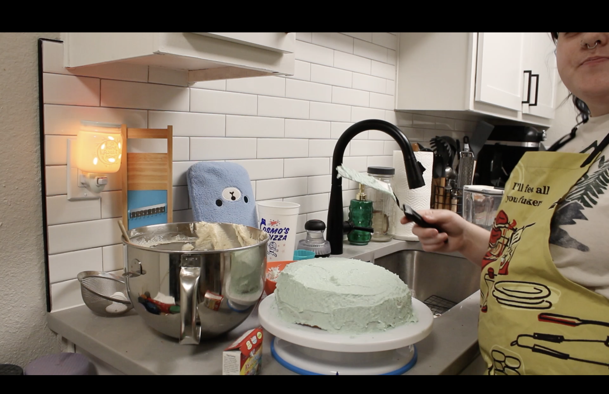 n a kitchen with the cake fully iced on a lazy Susan