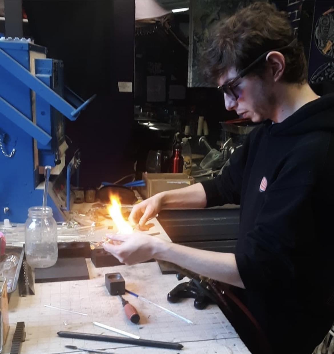 Artist is hand-blowing glass
