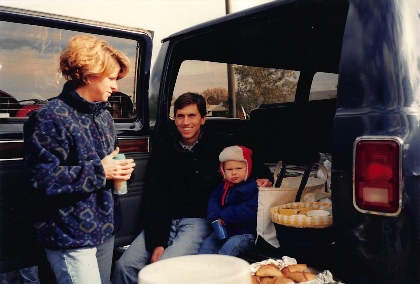 family sitting in the trunk of a car