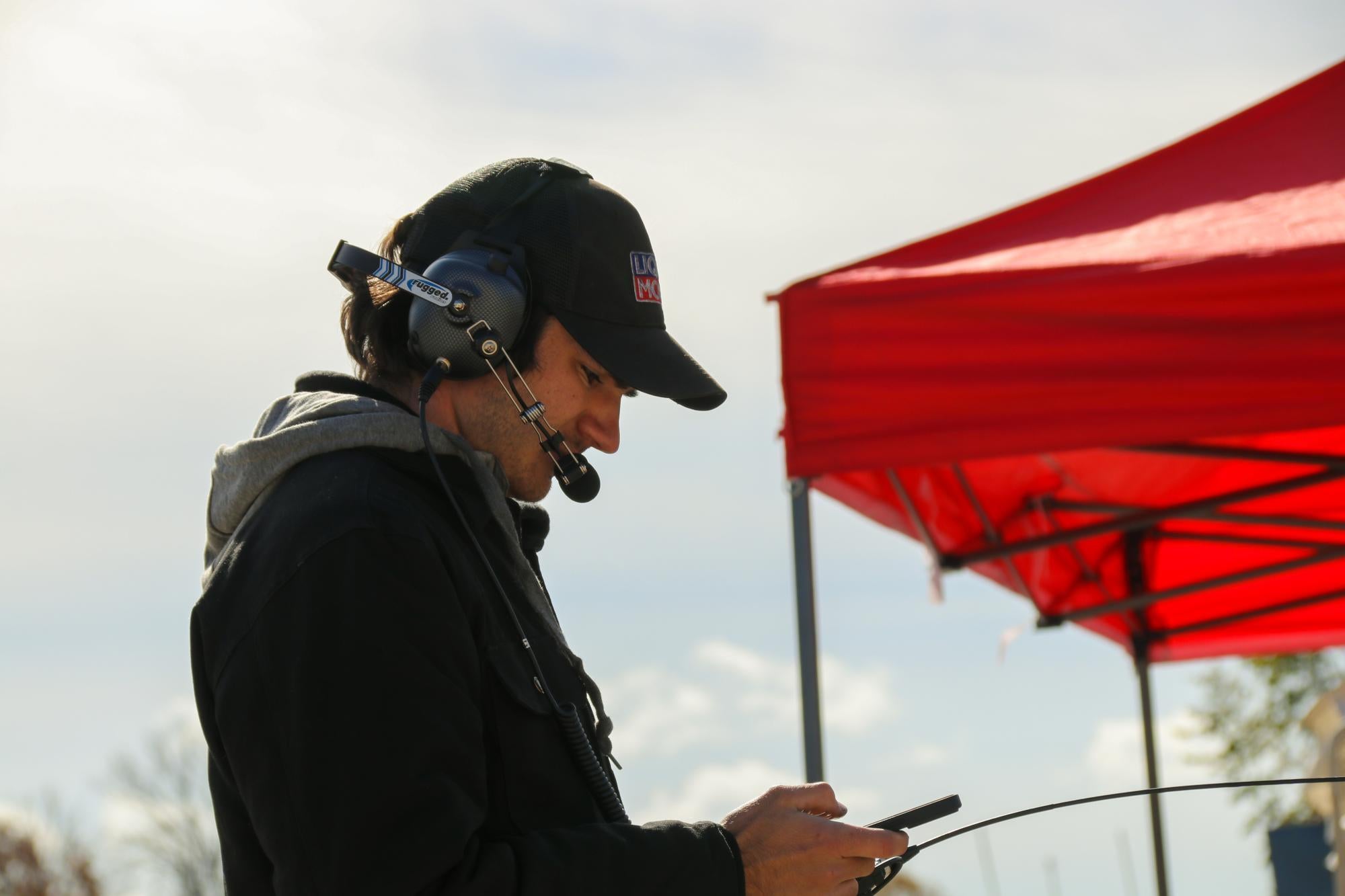 Tyler looking at standings while in communication with the driver