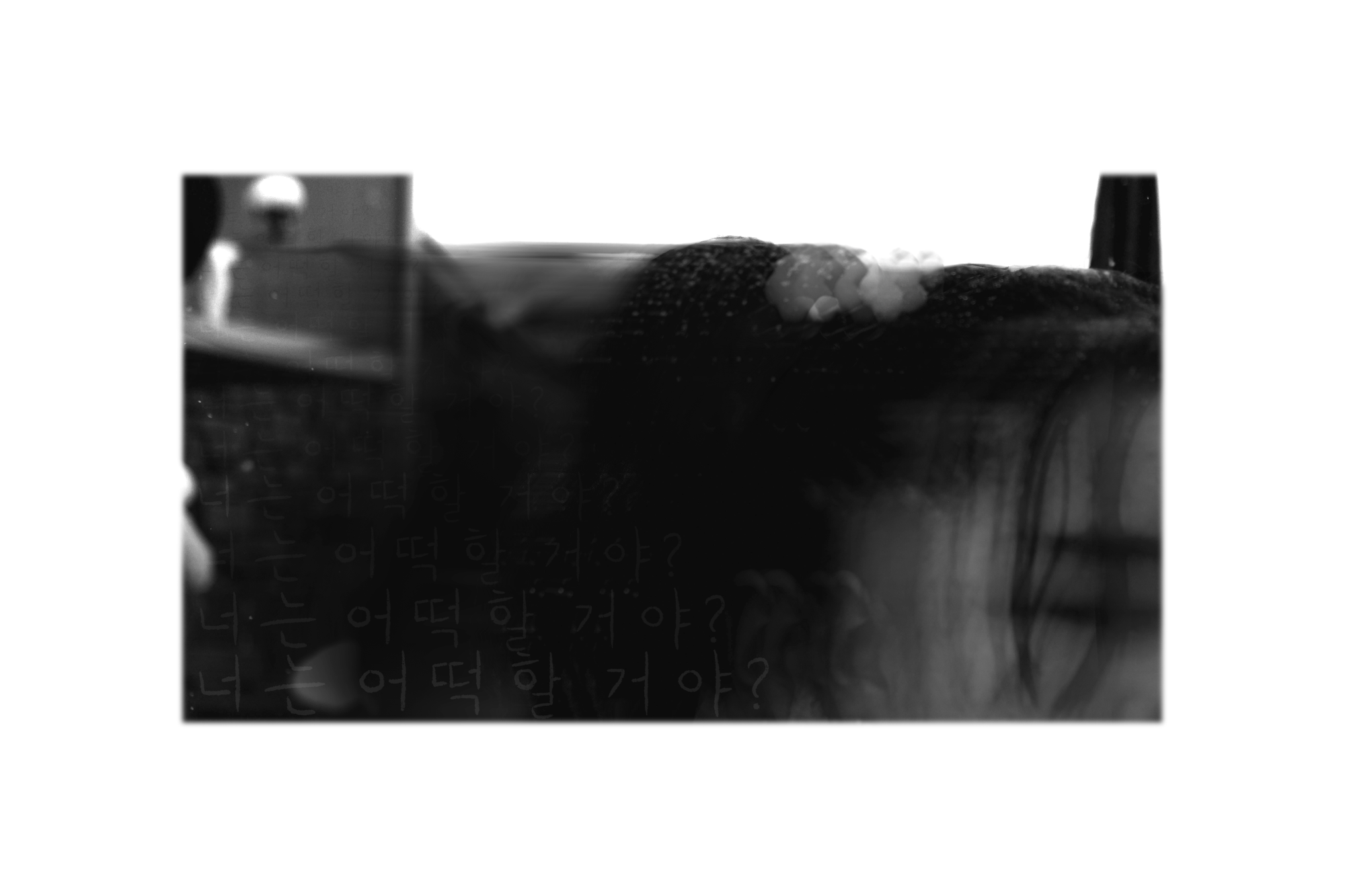 lack and white photo of a blurred figure, with faint Korean writing