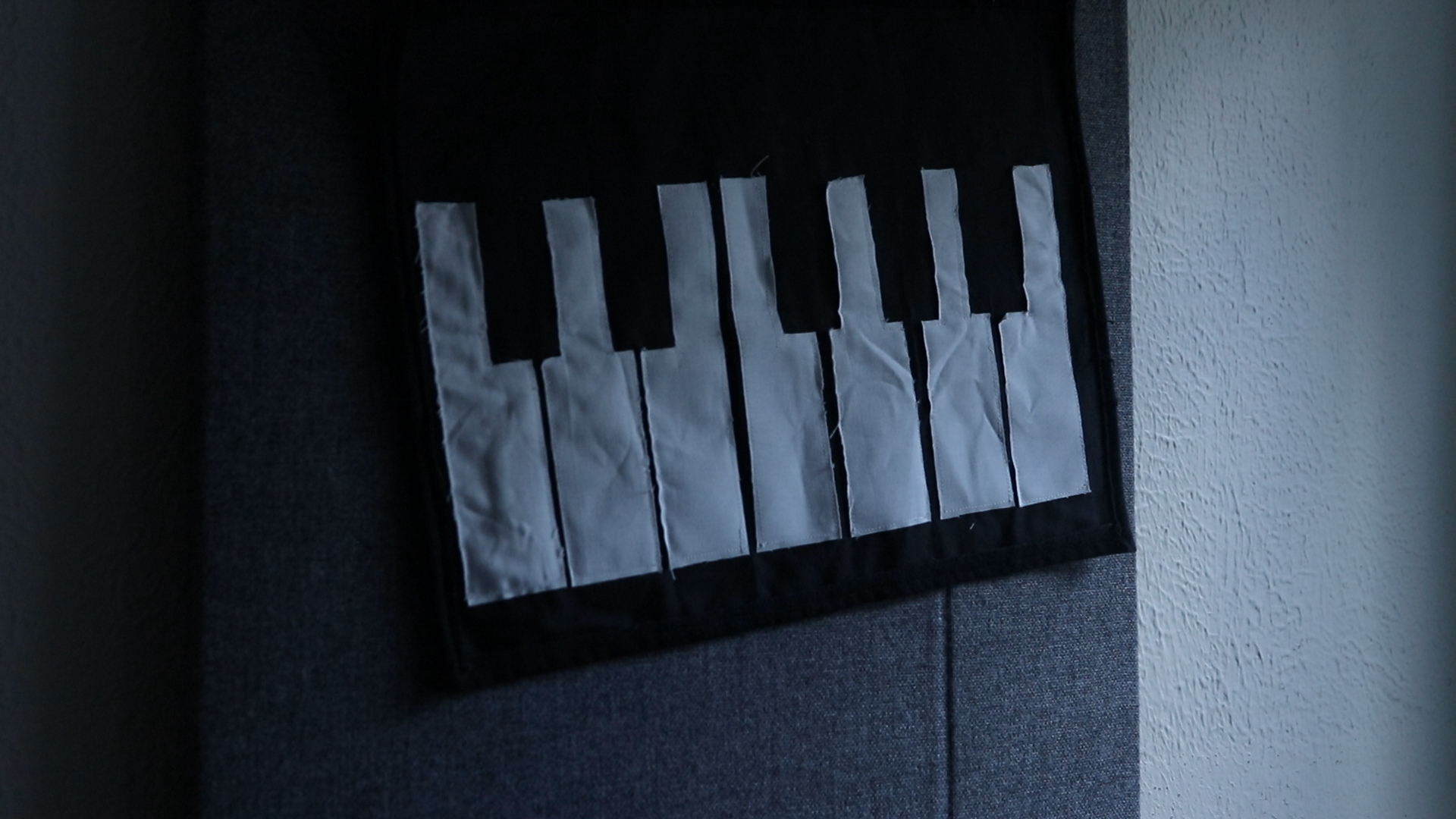 felt banner with piano keys hangs from wall