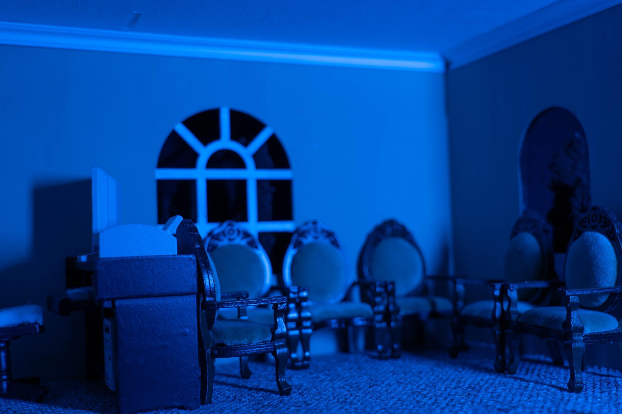 Wide angle shot of the office waiting room, the lighting is low and blue as if it is nighttime