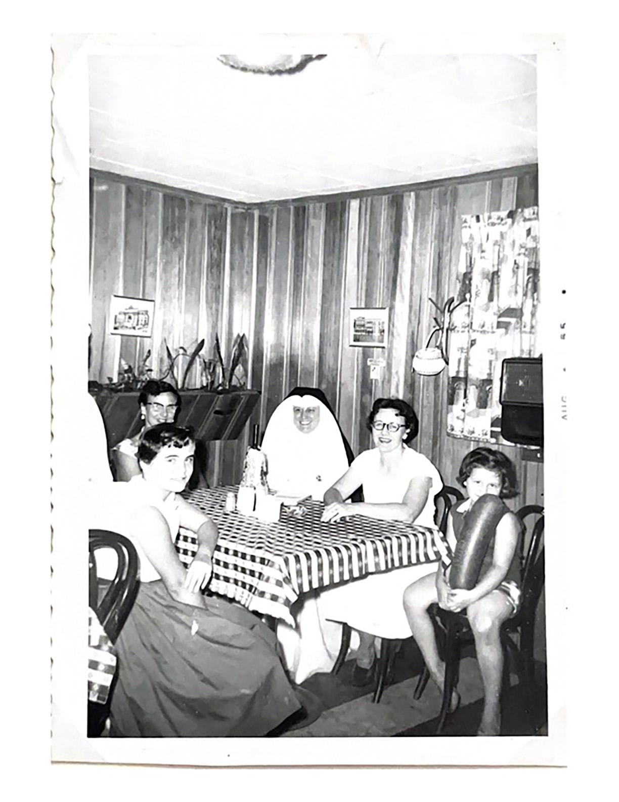 black and white picture of a family around a table