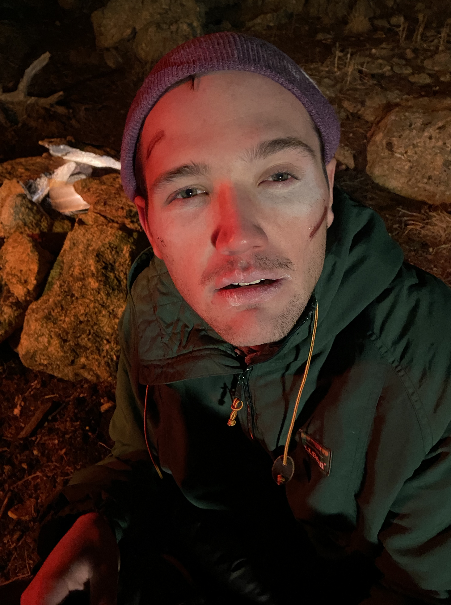 Man camping outside looks into the camera