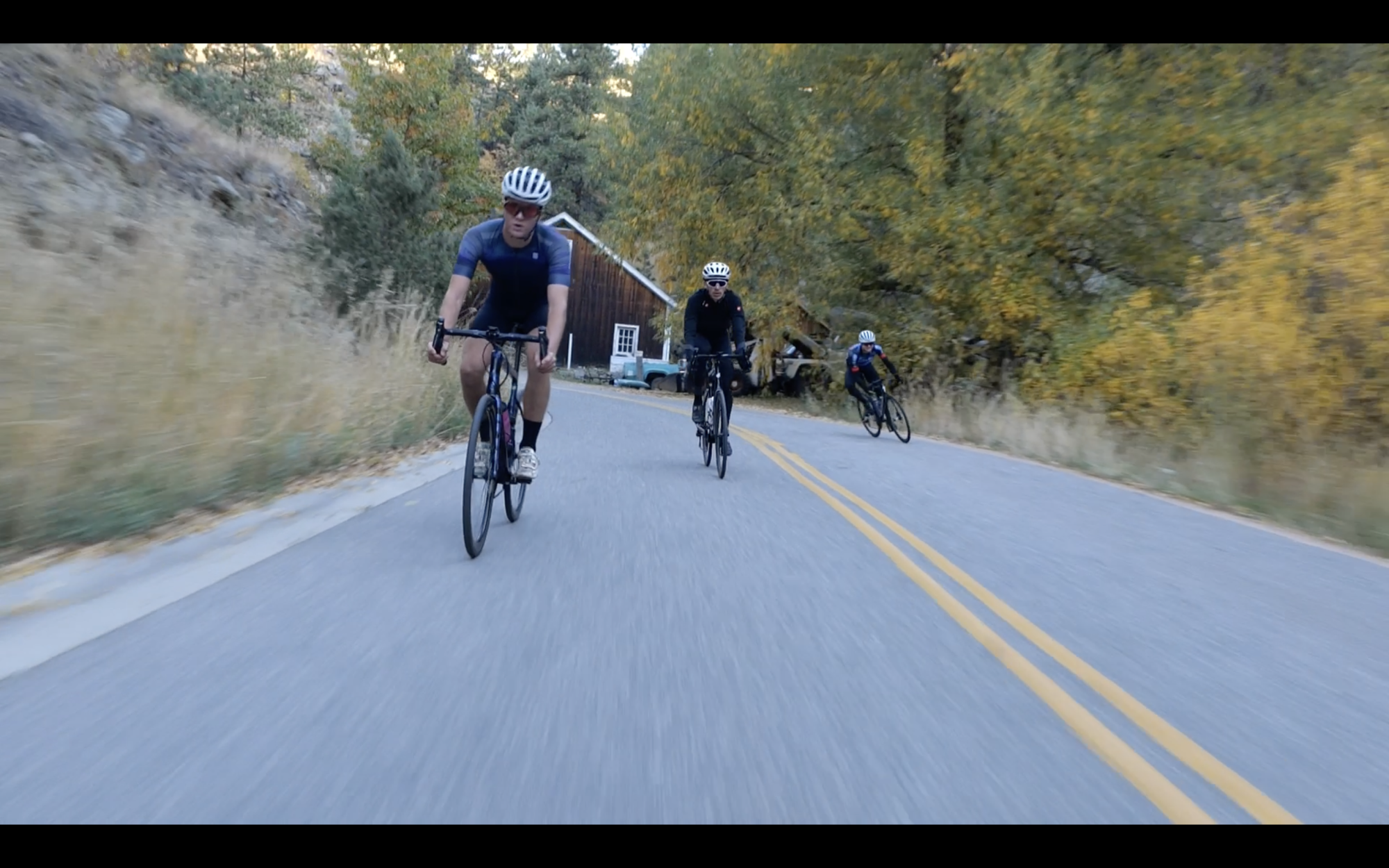 mountain bikers riding down a road