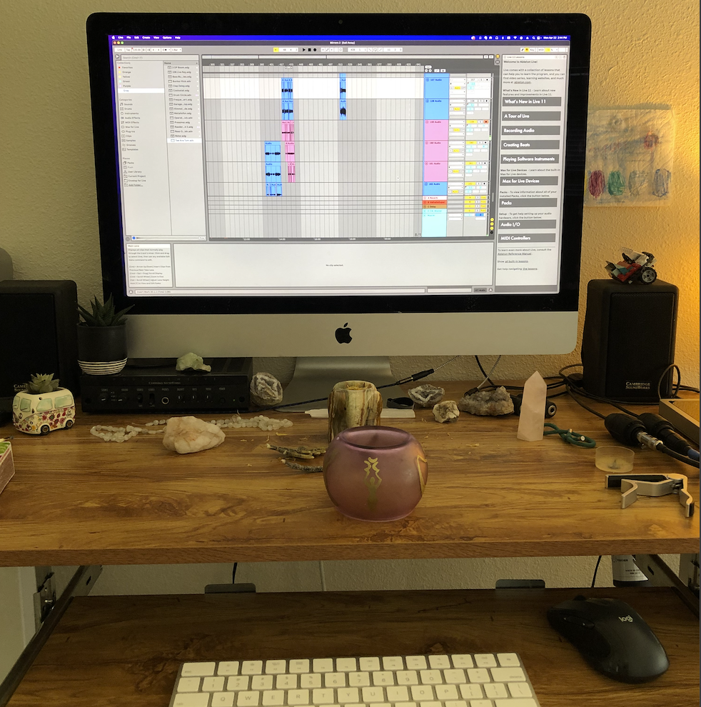 Desk setup with keyboard, computer, plants, and stones