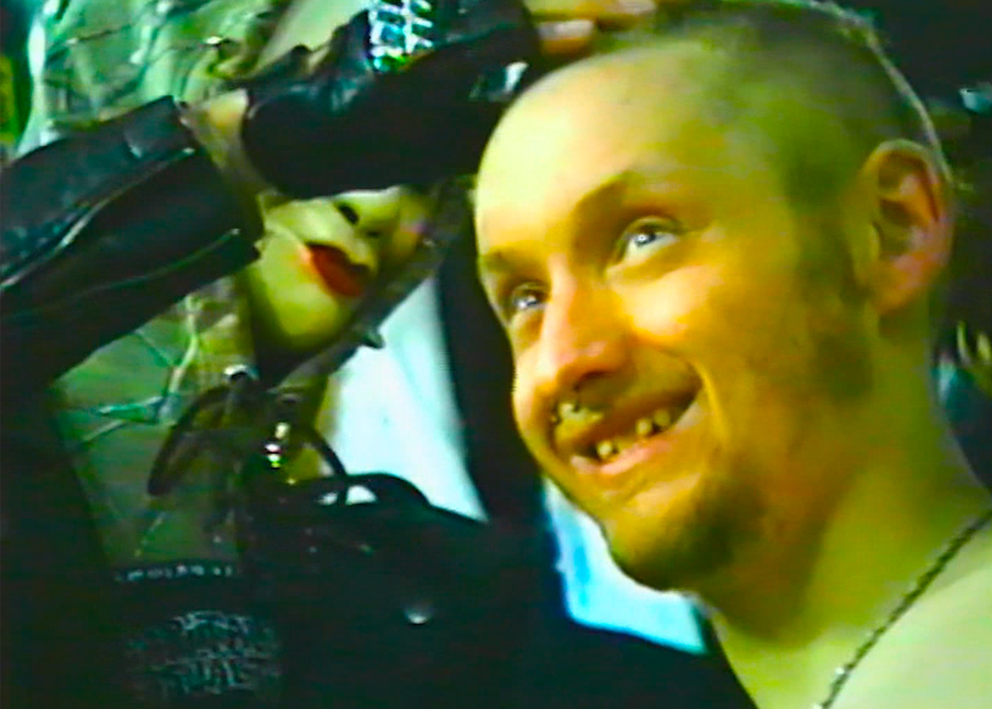 person with a shaved head smiling