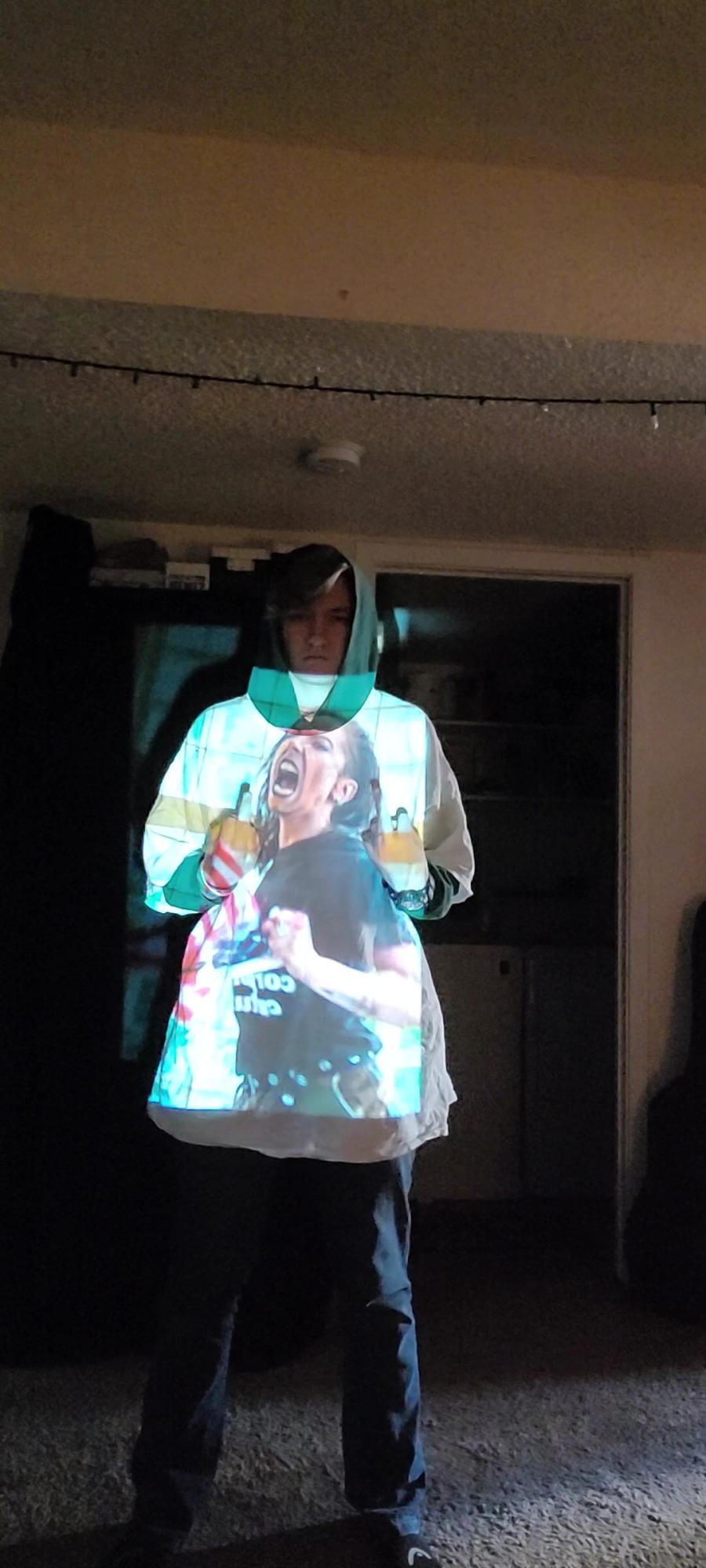 person wearing a large shirt with a projected image of a woman screaming on it