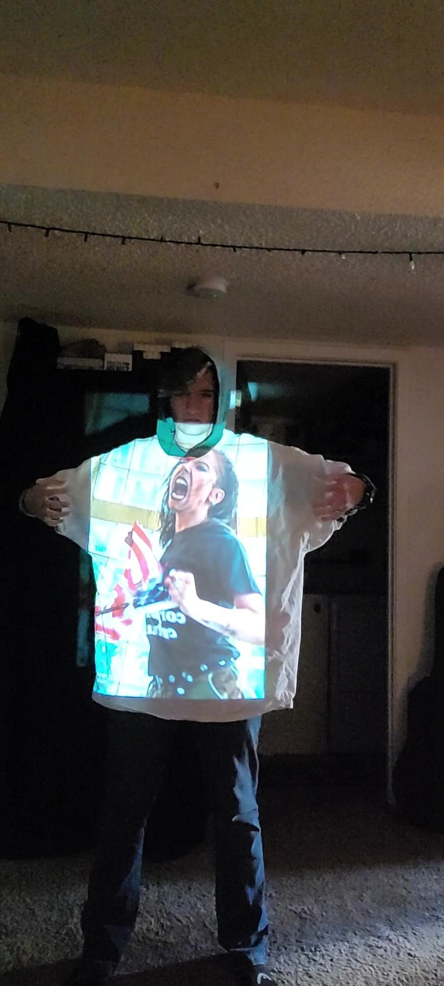 person wearing a large shirt with a projected image of a woman screaming on it