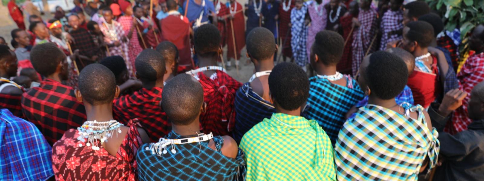 men huddled together wearing colorful robes