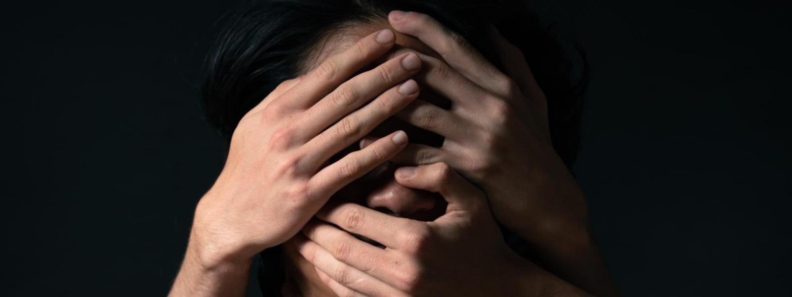 hands covering face