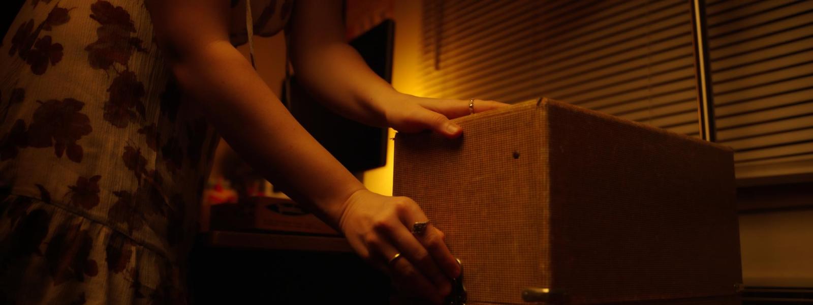 hands reaching toward a box