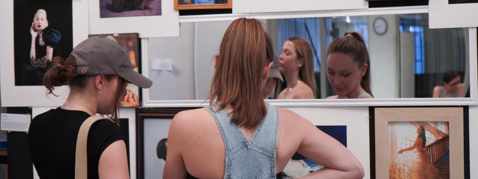 two women looking at artwork