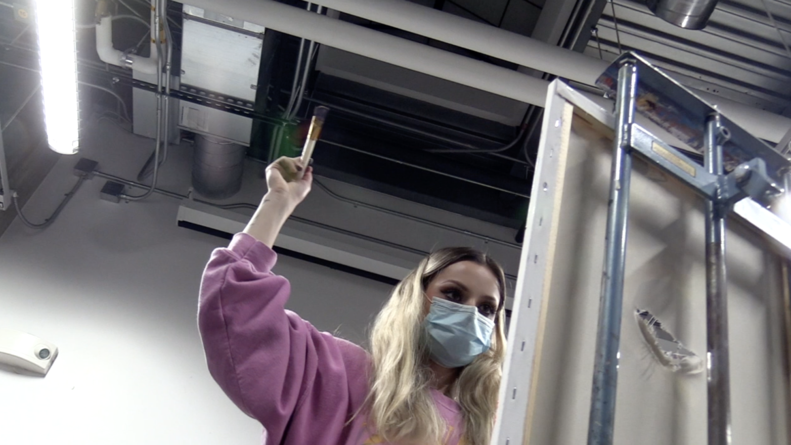 The girl wielding her brush against her painting just before it disappears.