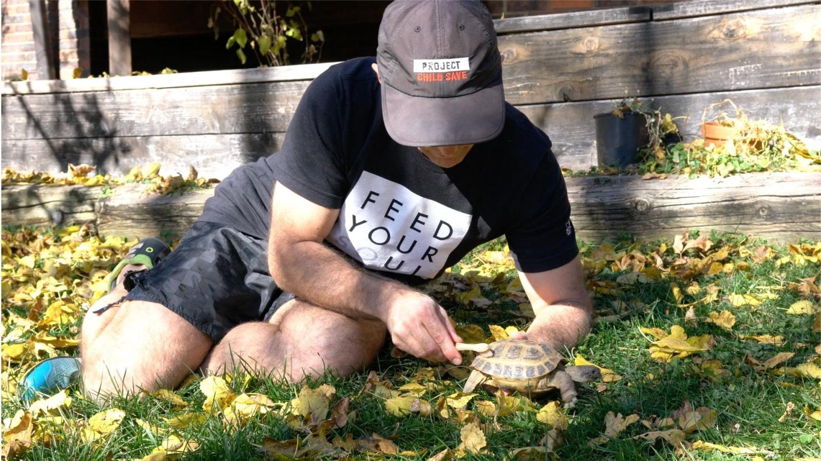 John Pierre cleaning turtle with toothbrush