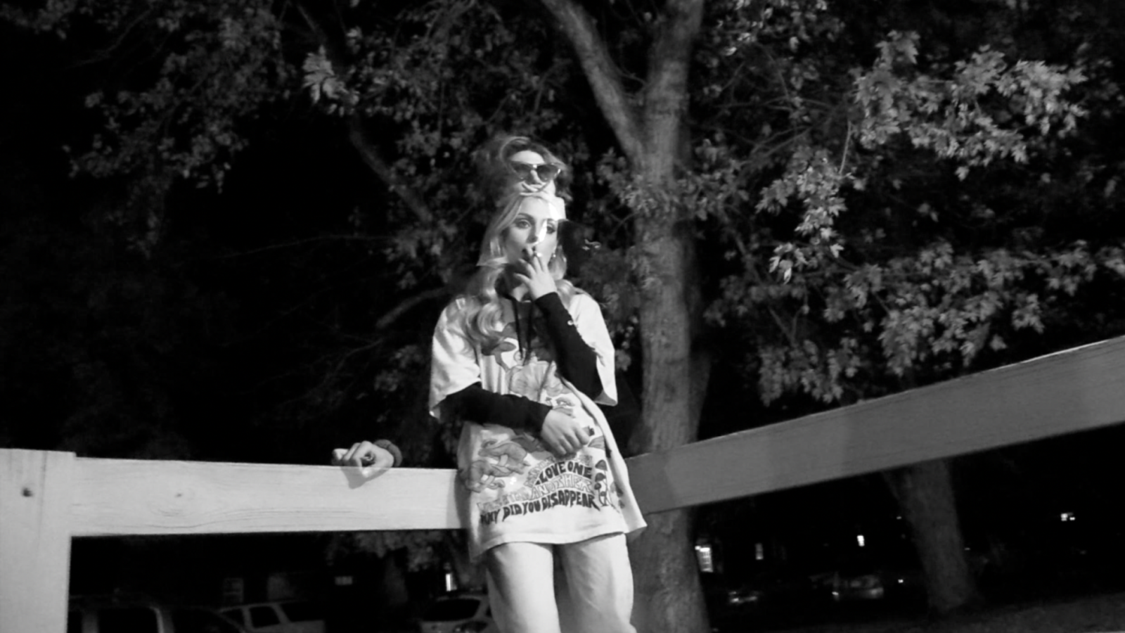 The girl fading into her murderous alter-ego. She stands in place smoking outside in the dark.
