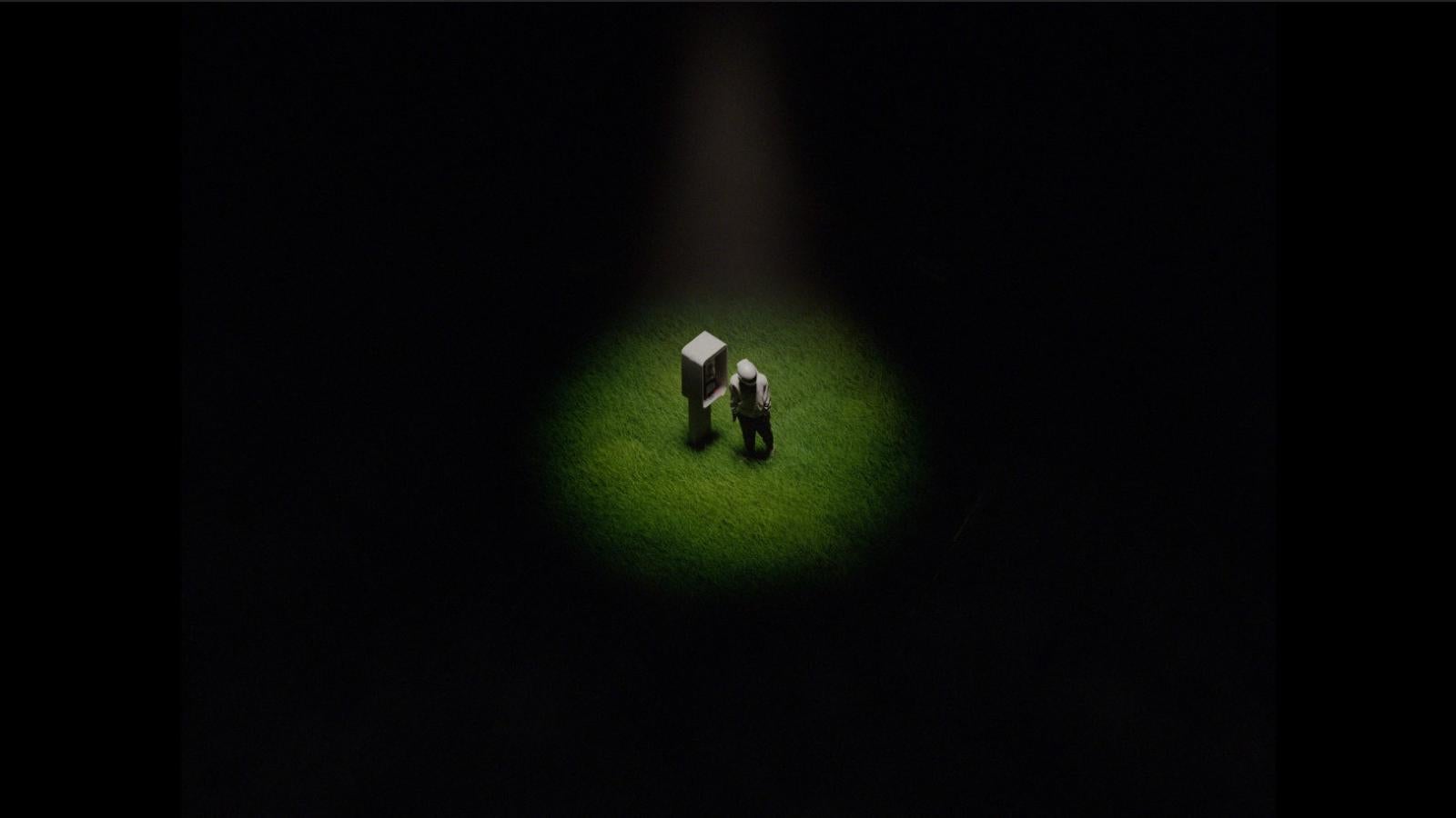 Main character alone in field, with a white phone booth in the center. This shot begins the sequence of more abstract shots, as the character falls into a drug trip from this point onward