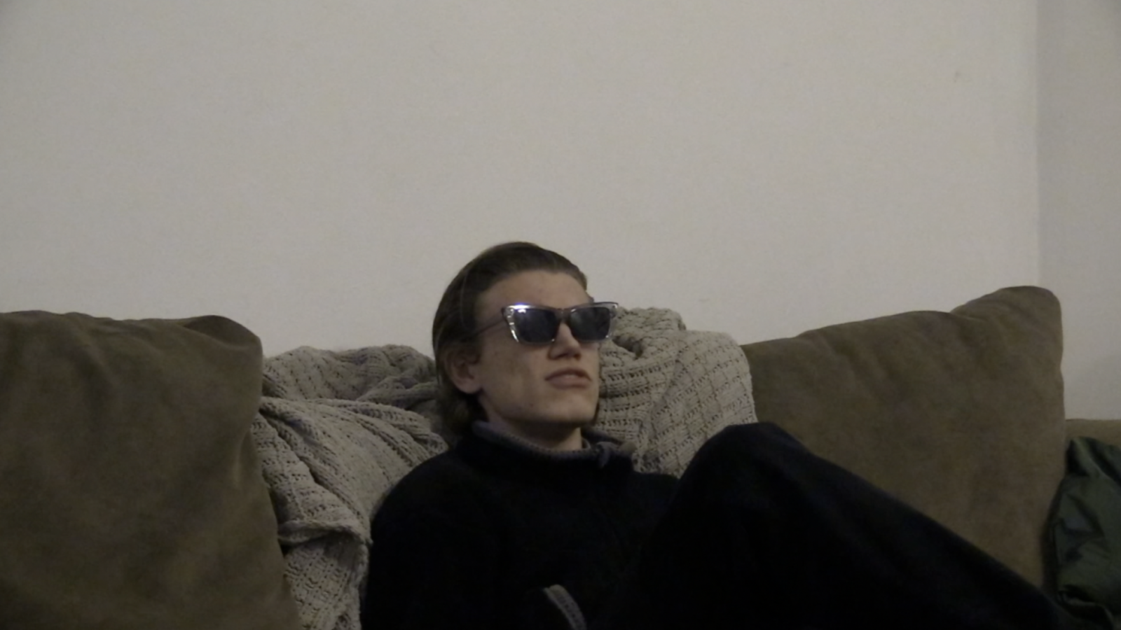 The man sits alone on a boring looking couch and chants the anonymous Tom O’ Bedlam song.