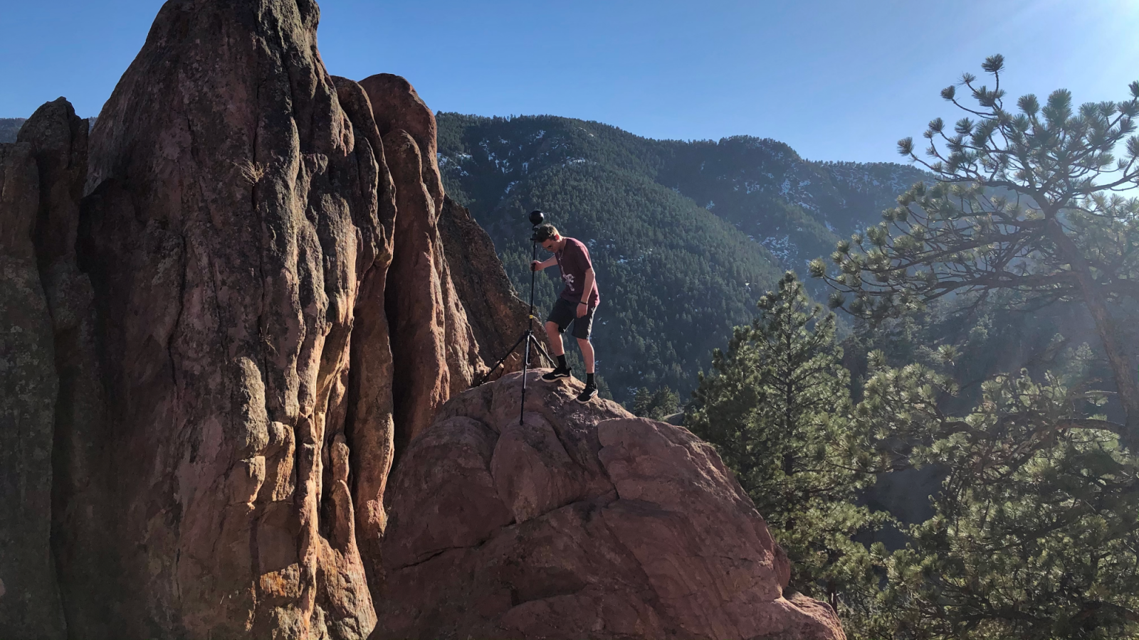 Artist with camera on cliff