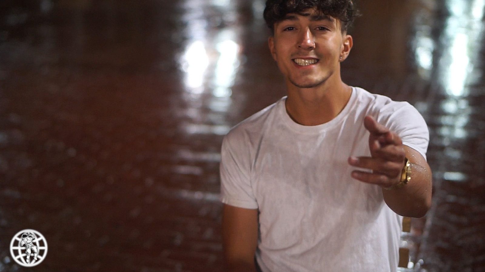 Man in a hall pointing at camera