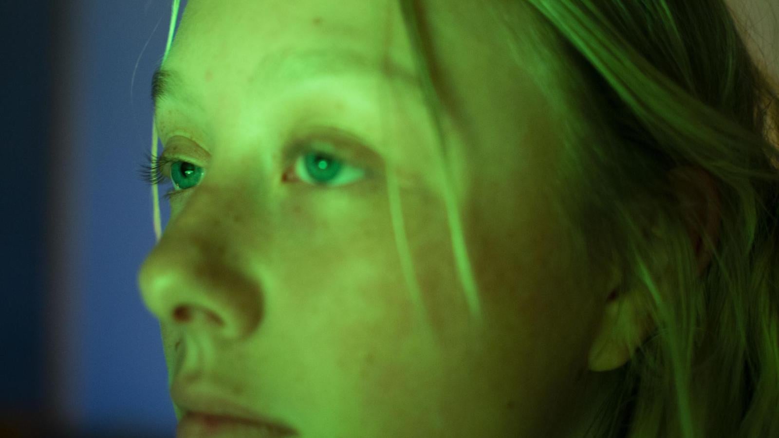 Person looks into a green light